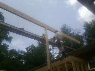 Carpenter setting a ridge beam over a new addition frame — Ice Dam Removal by Roofing Brothers in Rockmart