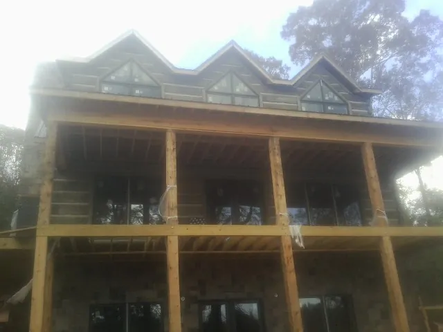 Dormers and porch framing on a large log home under construction — Roof Coating work by our crew in Rockmart