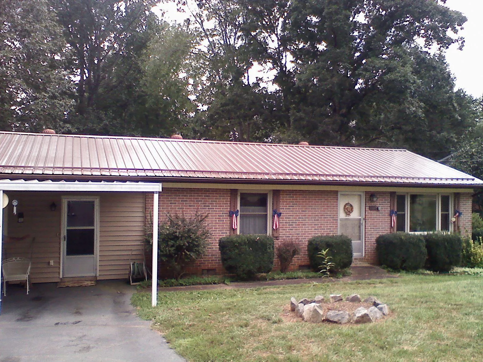 Bronze metal roof and carport on a brick ranch home — Roof Repair work by our crew in Rockmart